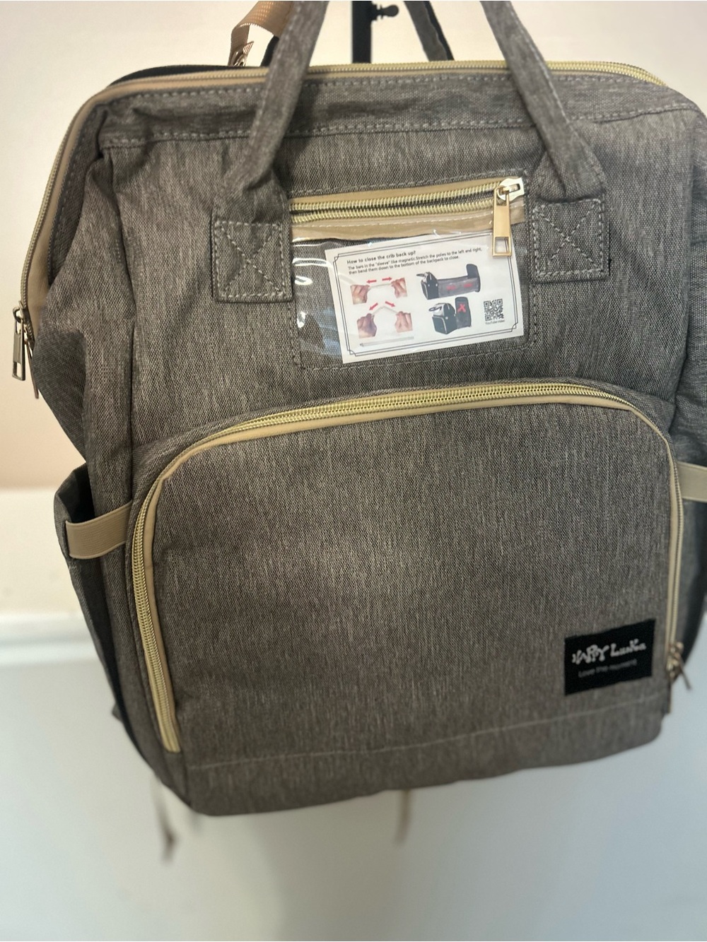 Happy Luoka 3-in-1 diaper bag backpack with built in travel crib & changing pad.